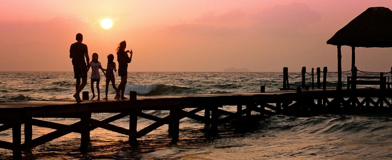people standing on dock during sunrise